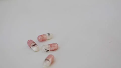 Macro shot of dropping capsule shells on a table Stock Footage 147699605