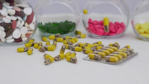 Macro shot of dropping yellow and brown granule capsule in bunch quantity Stock Footage 147699734