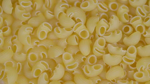 Macro shot of dry pasta shells. Pasta shells displayed with pantry and culinary Stock Footage 329527667