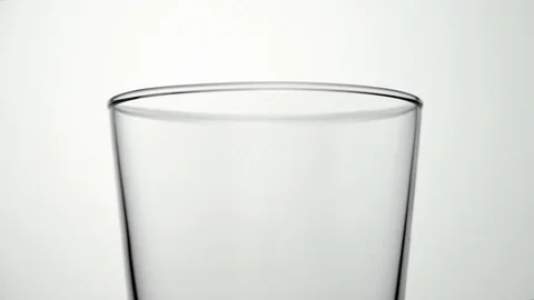 Macro shot of female hand taking jug of milk and pouring into empty glass Stock Footage 75954366