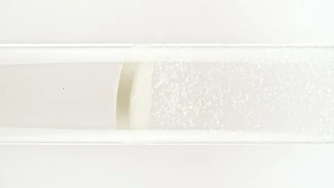 Macro shot of fine air bubbles rising in water in glass test tube on black Stock Footage 266940465