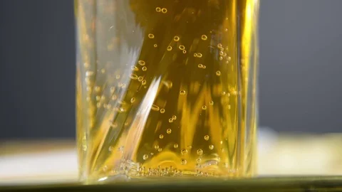 Macro Shot Of Fine Bubbles Rising In A Glass With Orange Liquid Stock Footage 121252082