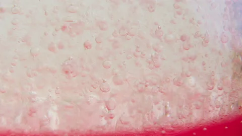 Macro shot of fine bubbles rising, In A glass with pink Liquid, slow motion Stock Footage 131105550