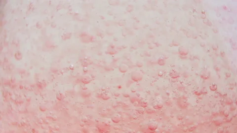Macro shot of fine bubbles rising, In A glass with pink Liquid, slow motion Stock Footage 131106237
