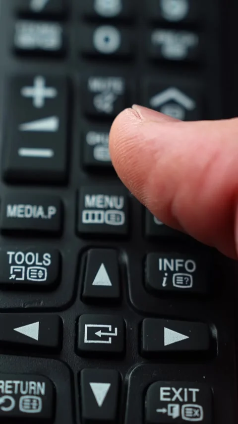Macro shot of a finger pressing the up arrow on a TV remote near mute and Stock Footage 331563003