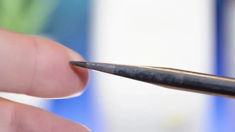 Macro shot of a flathead screwdriver rotating in a persons hand Stock Footage 299674091