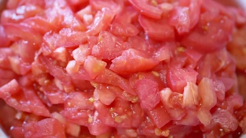 Macro shot of fresh chopped red tomatoes rotating slowly in a white bowl Vídeos de archivo 330118644
