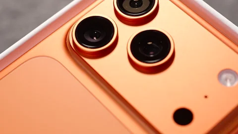Macro Shot of Glossy Apple Logo on Back of Cosmic Orange iPhone 17 Pro with Stock Footage 318057229