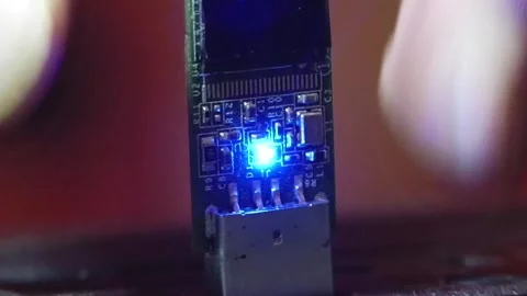 In a macro shot, a glowing flash drive into a computer and pull it back out Video stock 346881976