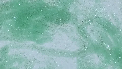 Macro Shot of Gold Particles made of Powder, Cosmetic Texture in Water Descend Video stock 248640275