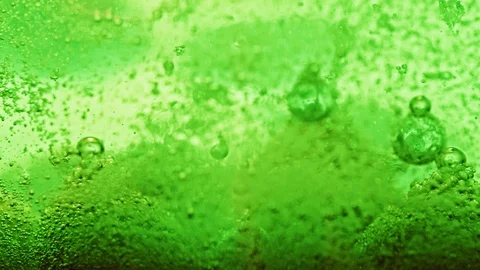 Macro shot of green bubbles dripping and moving around in bright green Video stock 124671239