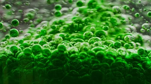 Macro shot of green bubbles getting mixed in water, floating around Video stock 124671194