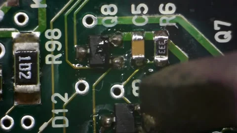 A macro shot of a green circuit board with a translucent glue drop Stock Footage 336711035