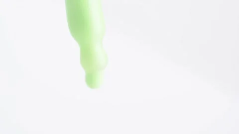 Macro shot of green moisturizing serum lotion falling from a glass pipette Stock Footage 268272519
