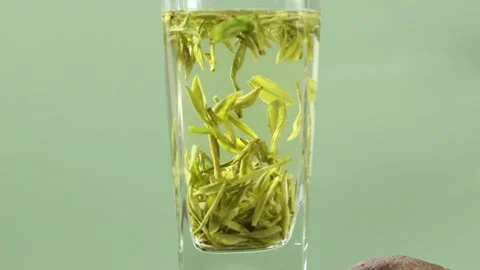 Macro Shot of Green Tea Leaves Brewing in a Glass Stock Footage 340617378