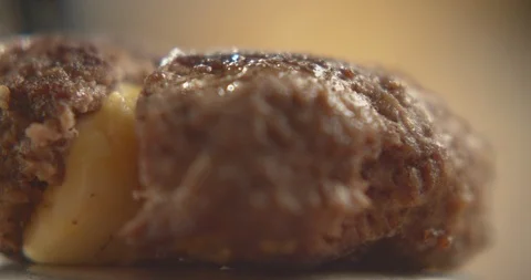 Macro shot of hamburger patty with flowing cheese filling. Slow motion video Stock Footage 116099720