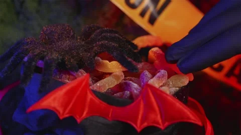 Macro shot of hand picking candy near spider in Halloween pouch Stock-Footage 342520326