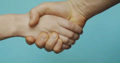 Macro shot of hands shaking isolated on blue background slow motion. Stock Footage 121431542