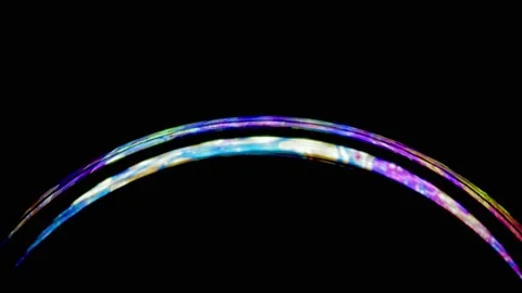 Macro shot of hemisphere of mesmerizing soap bubble with magical rainbow surface Stock Footage 146527432