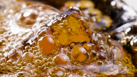 Macro Shot of Ice Cube Submerged in Bubbling soft drink Slow motion Stock Footage 174318148