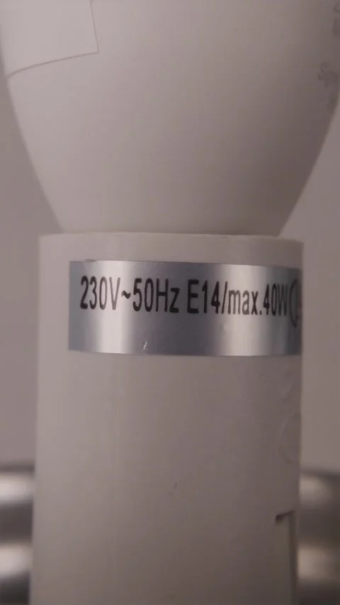Macro shot of lamp socket label showing electrical specs E14 40W Vidéo 347068973