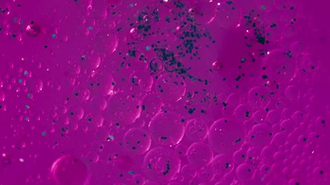 Macro Shot of Magenta Liquid with Bubbles and Glitter Particles Video stock 347181401