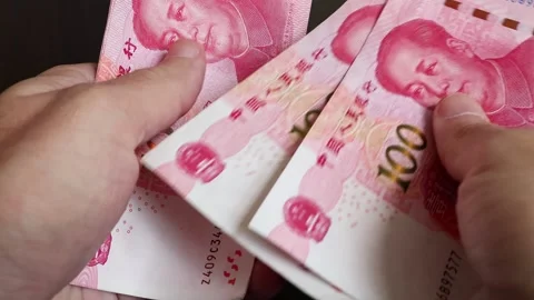 Macro shot of man's hands and Chinese Yuan (CNY) banknotes. Stock Footage 304454892