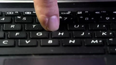 Macro shot of a man's left hand typing on a black laptop keyboard Stock Footage 342256437