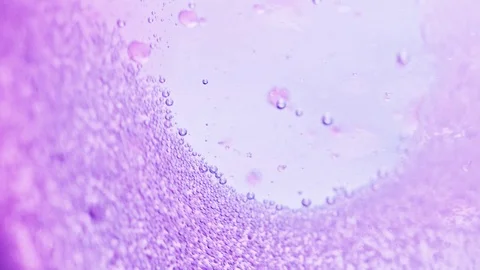 Macro shot of many small violet bubbles sparkling in water with a bright Video stock 124671165