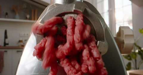 Macro shot of minced meat coming out of electric grinder. Strings of ground meat 库存影片 244467415