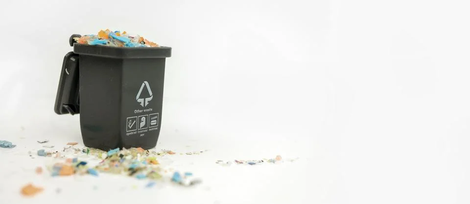 Macro shot of a mini plastic trash can full of micro plastics. Stock Photos