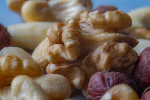 Macro shot of mixed nuts with focus on walnut, showcasing natural texture a.. Stock Photos