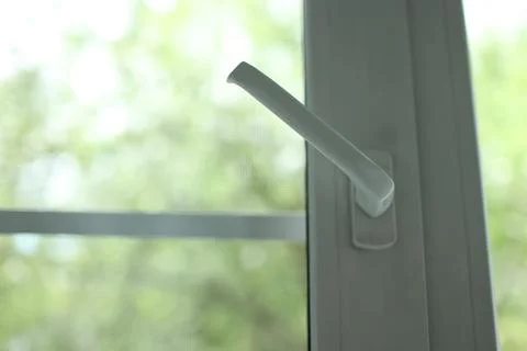 Macro shot of a modern window handle mechanism turned open to ventilate the Stock Photos