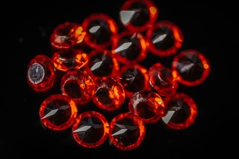 Macro shot of multiple bright red faceted gemstones. Stock Photos
