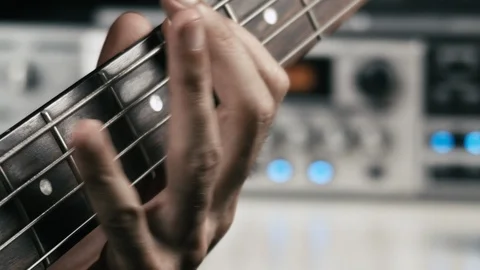 Macro shot of a musician's hand while he plays bass guitar. Vídeo Stock 113444606