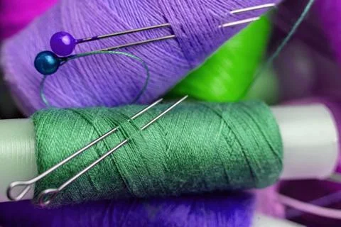 Macro shot of needle inserted in the  color thread rolls Foto stock