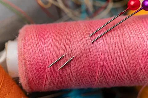 Macro shot of needle inserted in the  color thread rolls Foto stock