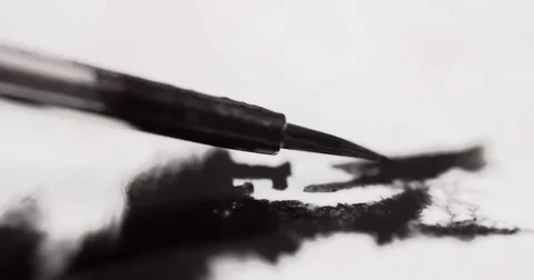 Macro shot of a paintbrush with black paint on white paper Stock Footage 73733149