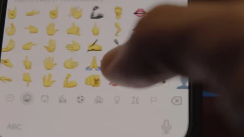 Macro shot of a person scrolling through the range of emojis available to use Video stock 293592862