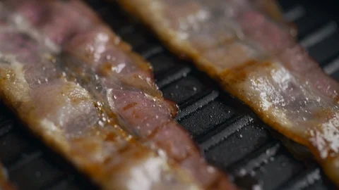 Macro shot of pieces of bacon being roasted on the hot grill pan, slow motion Stock Footage 114001967