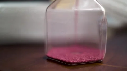 Macro Shot Of Pink Sand Particles In Hourglass Sand Timer Clock. Locked Stock Footage 240691050