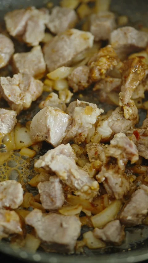 A macro shot of pork and onions frying in a pan Stock Footage 337016702