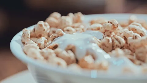 Macro Shot of Puffed Wheat Cereal with Creamy White Yogurt Vídeo Stock 335895262
