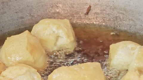 Macro shot of puffy white tofu cubes deep frying in hot oil. 動画素材 344556745