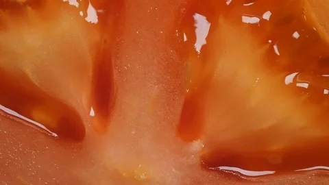 Macro shot of the pulp on a red fresh tomato half rotating Stock Footage 125782803