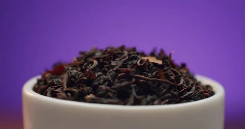 Macro shot of pure large frush ceylon leaf black tea rotating in small bowl on Stock Footage 146339547