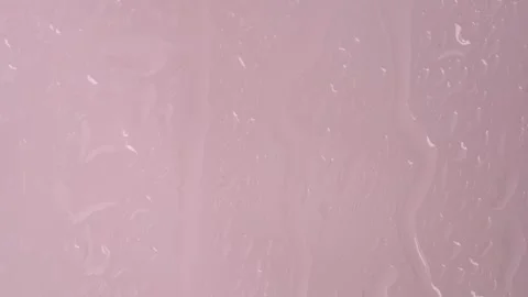 Macro shot of rain droplets on window. Water drops in window on light pink .. Stock Footage 269134927