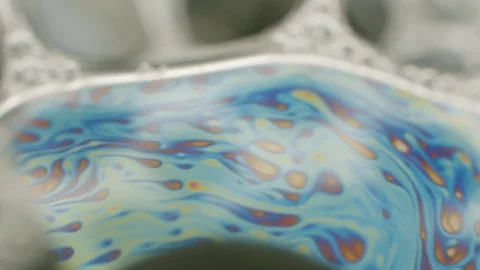 Macro shot of rainbow colored liquid on a transparent surface. Liquid Stock Footage 119961987