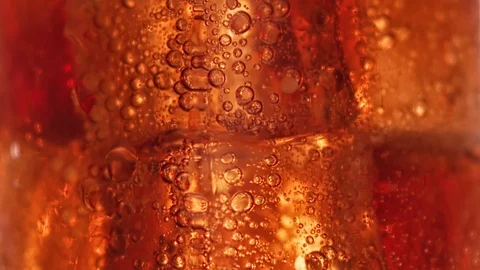 Macro shot raising up air bubbles at brown liquid iced cocktail. Shot on RED Stock Footage 129070439