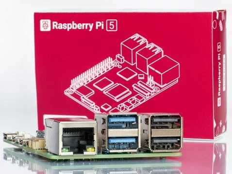 Macro shot of Raspberry Pi 5 ports and CPU board with red retail packaging Stock-Fotos